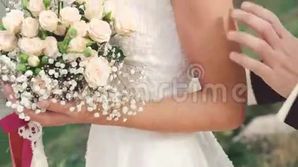新娘手中的婚礼花束新郎抚摸新娘4K视频的预览图
