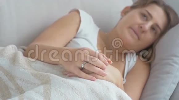 躺在床上揉搓手指的不安女人的特写镜头视频的预览图