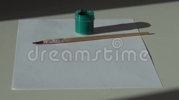 纸刷子和一罐绿色丙烯酸水粉颜料在标签上视频的预览图