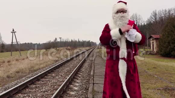 圣诞老人在铁路附近的站台上放着礼品袋视频的预览图