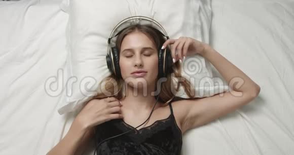 性感女人在床上戴着大耳机视频的预览图