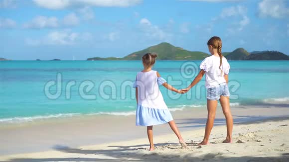小快乐有趣的女孩在热带海滩玩得很开心阳光明媚的一天大海里有雨视频的预览图