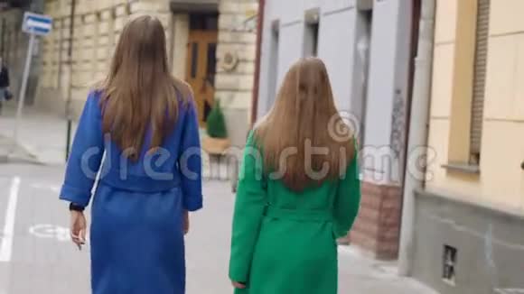女人穿着羊绒大衣走在街上的背影慢慢地视频的预览图