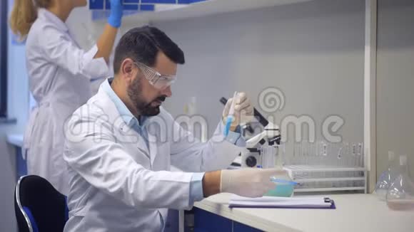 在实验室进行化学实验的男科学家视频的预览图