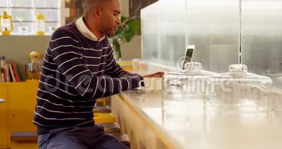 男性高管在自助餐厅使用笔记本电脑时喝咖啡视频的预览图