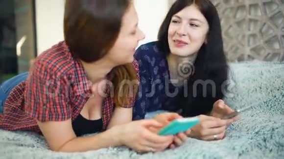 两个快乐的女性朋友用智能手机分享社交媒体聊天视频的预览图