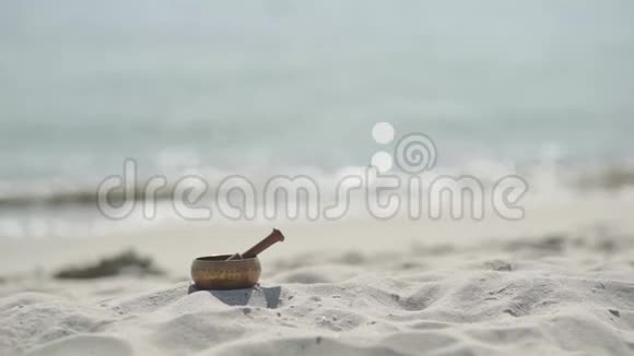 在沙滩上打坐的青铜藏语唱碗视频的预览图