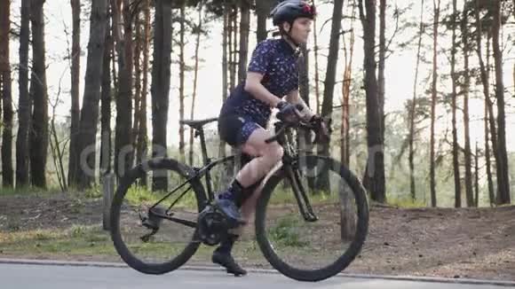 年轻的骑自行车的女人开始踩自行车公路自行车铁人三项的概念慢动作视频的预览图