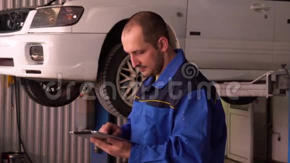 汽车机械师用数字平板电脑检查汽车电子诊断的读数视频的预览图
