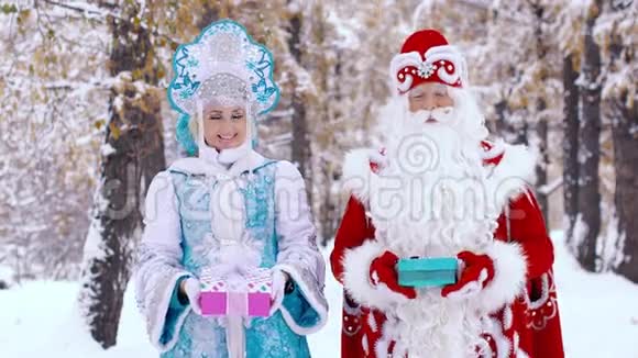 弗罗斯特神父和微笑的雪少女向镜头展示礼物的肖像视频的预览图