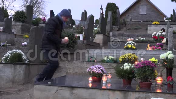 哀悼者跪在墓地上手里拿着燃烧的蜡烛祈祷4K视频的预览图