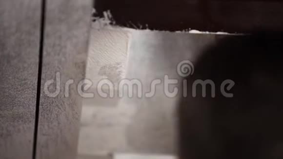 男工的双手用大刷子把灰色的墙壁刷成白色视频的预览图