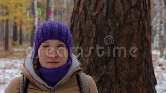 一个女孩的肖像靠近一棵大树落叶松特写视频的预览图