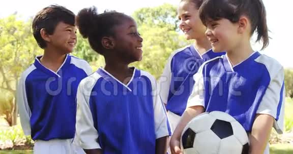 一群微笑的孩子站在足球旁边视频的预览图