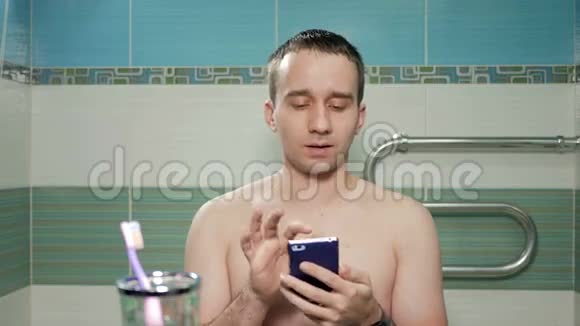 年轻迷人的男人在浴室做自拍酒店房间他微笑着改变姿势不穿T恤衫视频的预览图