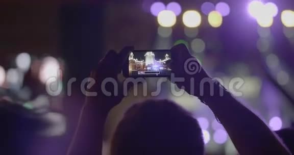 观众在室外音乐音乐会上用智能手机拍摄舞台全景照片视频的预览图