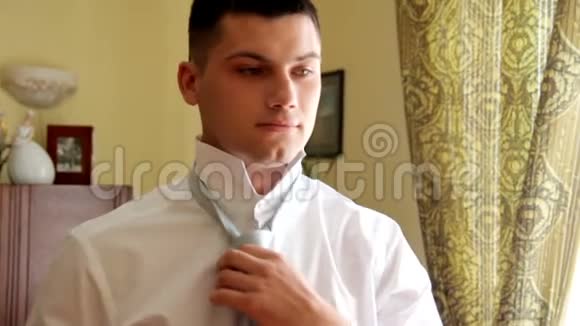帅哥穿着领带微笑结婚纪念日新郎系着领带视频的预览图