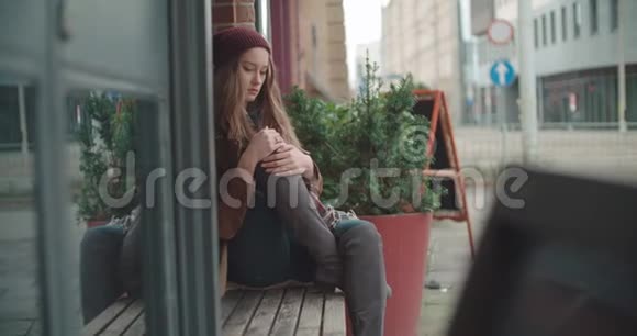 美丽悲伤焦虑的女人独自坐在城市里视频的预览图