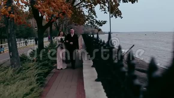 优雅的男人和女孩走在海滨视频的预览图