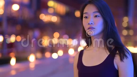 快乐的亚洲女人晚上在户外思考视频的预览图