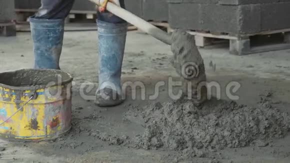 工人铲拌混凝土并在施工现场放入桶中视频的预览图