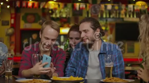 一群年轻的朋友在酒吧里喝酒笑视频的预览图