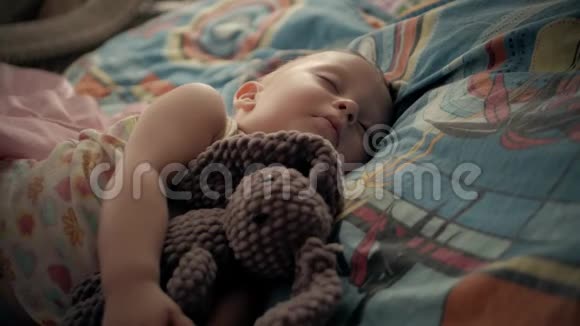 可爱的小男孩和泰迪熊睡在一起视频的预览图