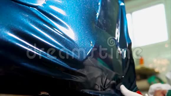 专家在车库表面光滑的机器粘贴乙烯基视频的预览图