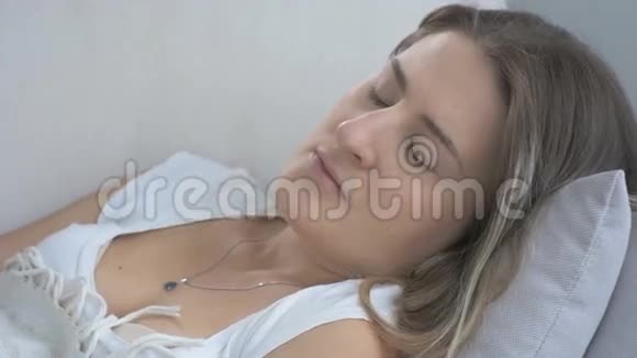 躺在枕头上咳嗽的年轻病妇的特写镜头4K分辨率拍摄的录像视频的预览图