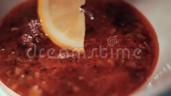 把食物夹起来厨师把一片柠檬放进汤里撒上草药传统俄罗斯汤视频的预览图