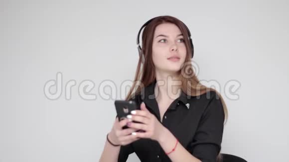 漂亮的年轻女孩戴上无线耳机摆出自拍照片视频的预览图