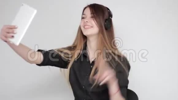 戴着耳机跳舞听音乐拍平板电脑的快乐年轻女子视频的预览图