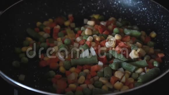 翻炒冷冻蔬菜用锅铲炒蔬菜把蔬菜拌在锅上健康烹饪视频的预览图