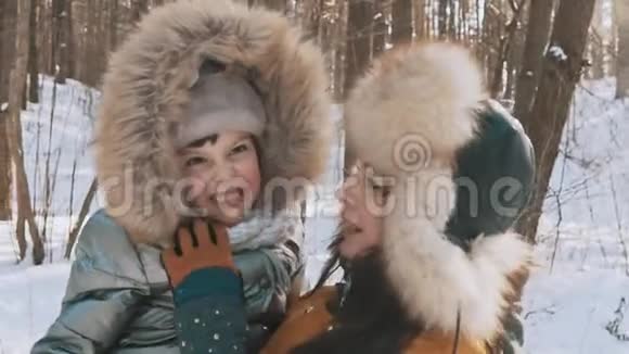 母亲和小女儿在冬季公园享受寒冷的阳光天气视频的预览图