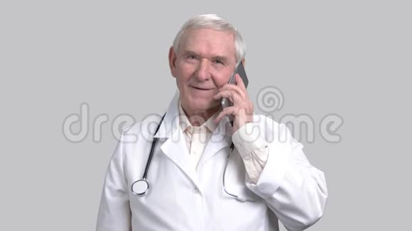 微笑的高级医生在手机上交谈的肖像视频的预览图