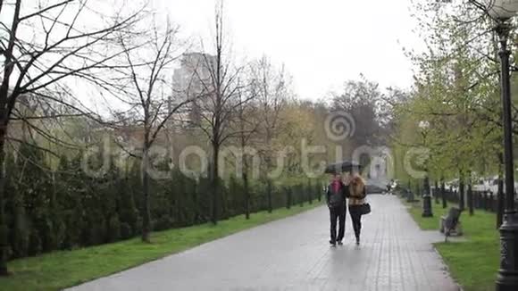 年轻夫妇在伞下散步视频的预览图