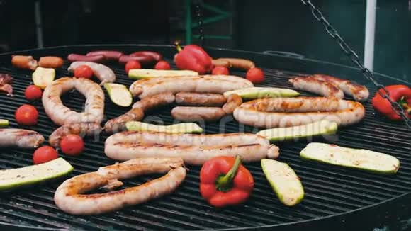 不同的香肠用蔬菜烤在大烤架上美食节视频的预览图
