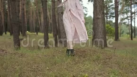 动作缓慢漂亮的女孩戴着眼镜穿着有趣的衣服在树林里对着镜头摆姿势视频的预览图