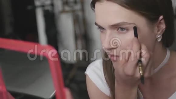做化妆女孩一双慈祥的眼睛看着镜子用特殊的铅笔4k视频的预览图