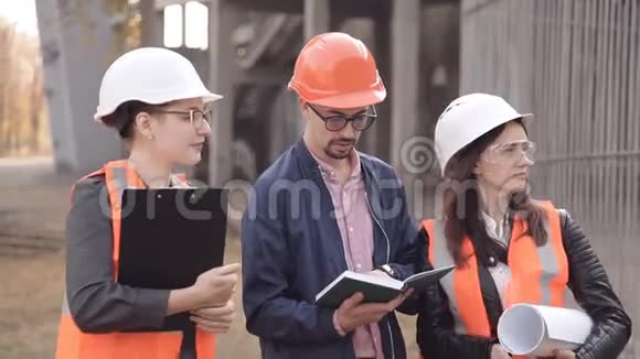 两个女人和一个男人正在检查建筑视频的预览图