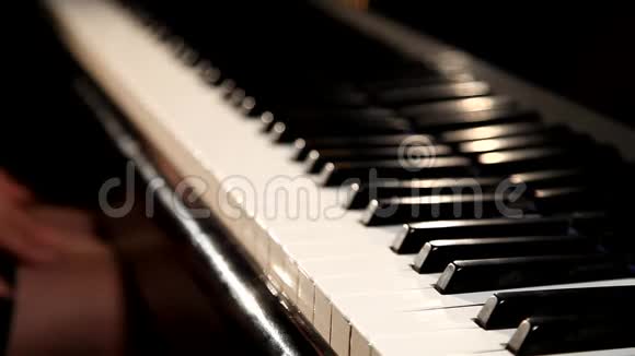 两只手在一架漂亮的大钢琴上演奏视频的预览图