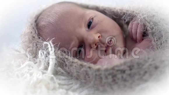 一张漂亮的婴儿脸被羊毛遮住的照片视频的预览图
