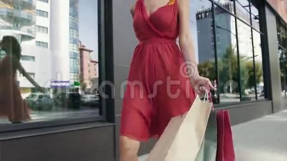 有魅力的年轻女子带着她买的东西从购物中心回来视频的预览图