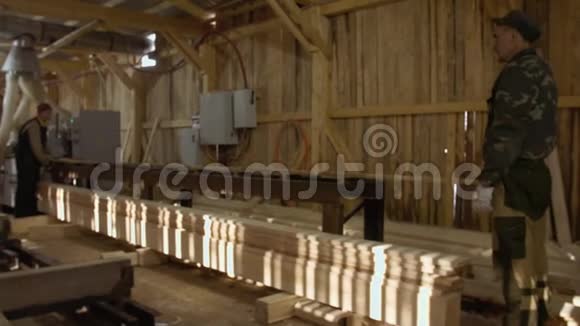 木匠在木材厂把木材木板放在连接机上视频的预览图