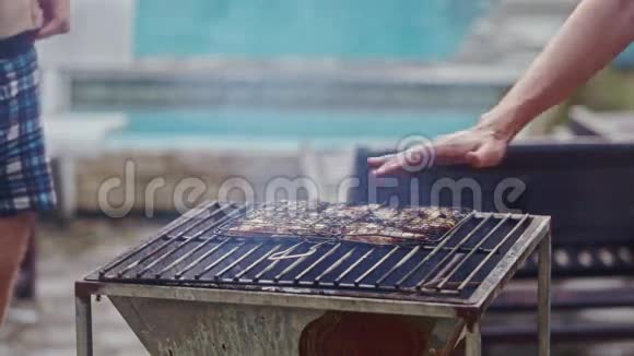 金属烤炉上的烤肉和人控制热量视频的预览图