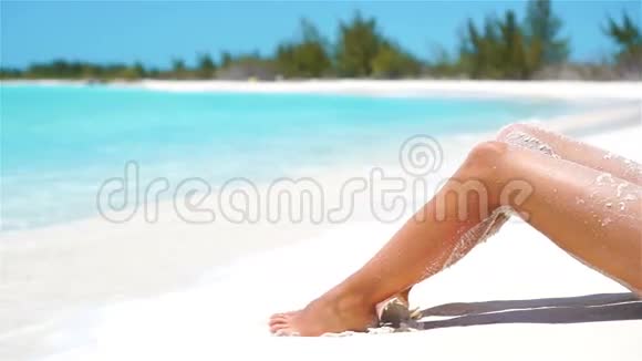 在白色的热带海滩上雌性苗条的晒黑腿慢视频视频的预览图