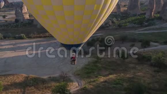 一个黄色的大气球的跨度在一个人的篮子里特写飞越群山卡帕多西亚全景视频的预览图