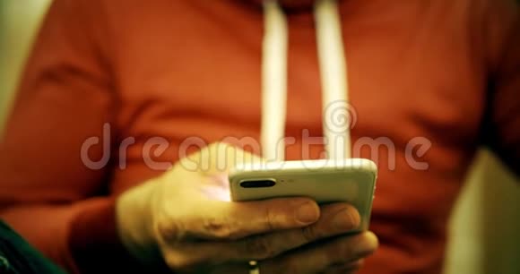 穿红色便服的男人用智能手机视频的预览图