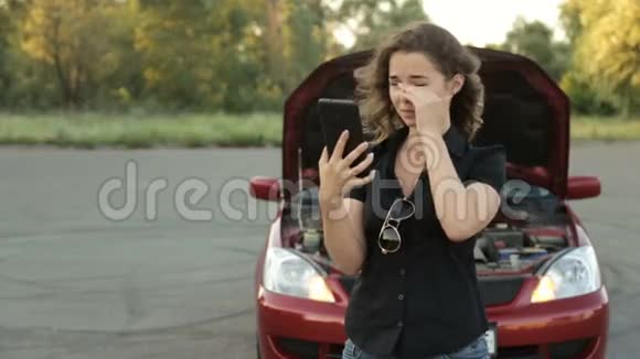 一个激动的女孩和一辆破车在路上给汽车服务部门打电话视频的预览图