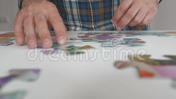 一个男人在公寓的桌子上收集大拼图视频的预览图